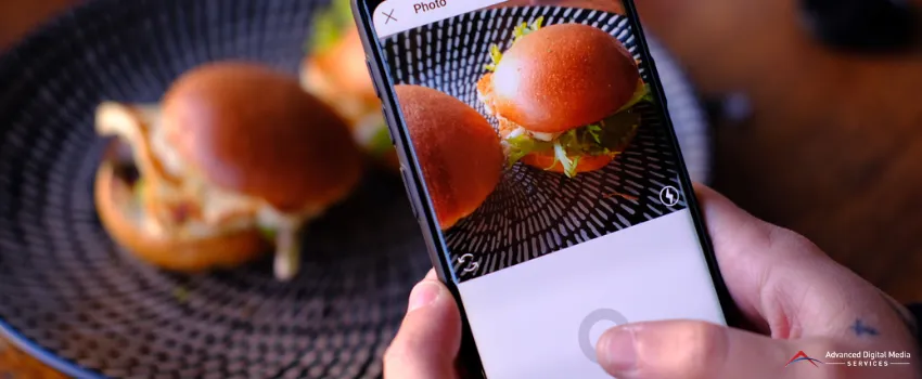 ADMS - An Instagram user taking a picture of two burgers on a plate