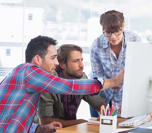 ADMS Team of designers working on a computer