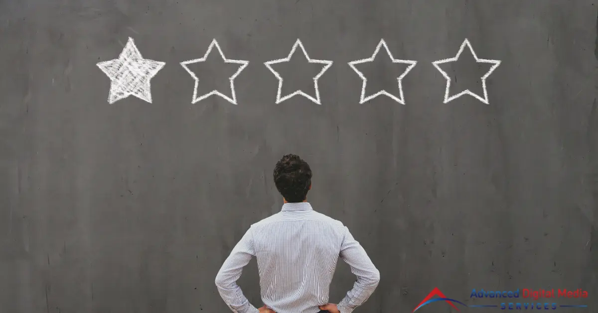 A man standing in front of a concrete gray wall with one star review drawing